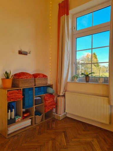 Regal im Seminarraum mit Yogaequipment wie Blöcken, Decken, Bolstern und Gurten.
