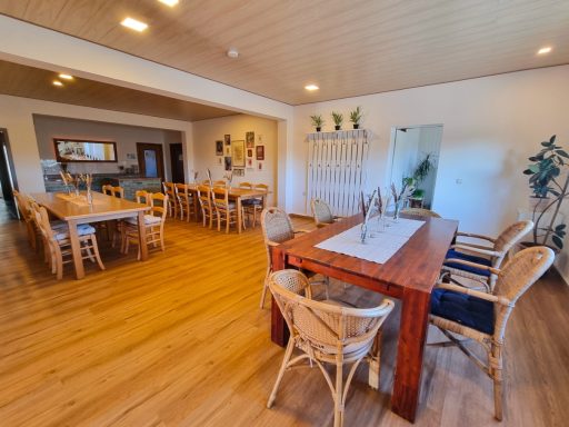 Essbereich mit Holztischen, Stühlen und Buffet-Theke im Hintergrund.