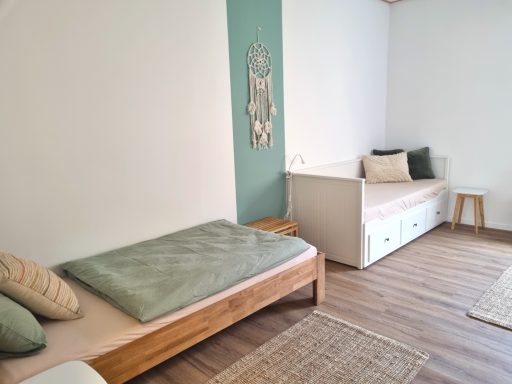 Einzelbett und Tagesbett im Vierbettzimmer mit ruhiger, natürlicher Einrichtung.