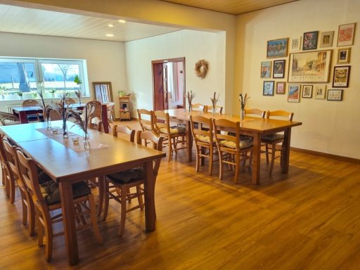 Gastraum mit langen Holztischen und Sitzplätzen für Gruppen.