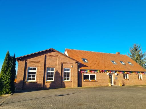 Außenansicht des Backsteingebäudes mit Parkplatz vor dem Seminarhaus.
