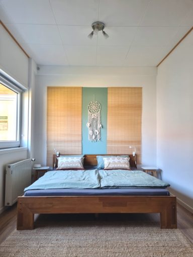 Großes Doppelbett im Vierbettzimmer mit ruhigen Farben und natürlicher Einrichtung.